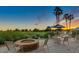 Outdoor patio area with tables, chairs, umbrellas, firepit and golf course views at 18226 W Stinson Dr, Surprise, AZ 85374