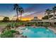 Community swimming pool at sunset with lounge chairs, and lush greenery at 18226 W Stinson Dr, Surprise, AZ 85374