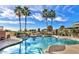 Community swimming pool with waterfalls, lounge chairs, palm trees, and golf course views at 18226 W Stinson Dr, Surprise, AZ 85374