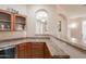 Entertainer's wet bar with custom cabinetry, granite counters, and wine storage at 18226 W Stinson Dr, Surprise, AZ 85374