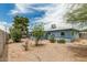 Expansive backyard with desert landscaping, mature trees, and partial patio cover at 2019 W Stella Ln, Phoenix, AZ 85015