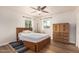 Comfortable bedroom with wood floors, ceiling fan, and two windows at 2019 W Stella Ln, Phoenix, AZ 85015