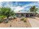 Charming single-story home with desert landscaping and a covered carport on a sunny day at 2019 W Stella Ln, Phoenix, AZ 85015