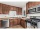 Functional kitchen featuring wood cabinets, stainless steel appliances, and tile floors at 2019 W Stella Ln, Phoenix, AZ 85015