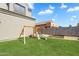 Spacious backyard with a wooden swing set, a slide, and well-maintained green grass at 21266 S 213Th Pl, Queen Creek, AZ 85142