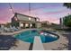 Backyard pool with diving board surrounded by lounge chairs, with string lights and landscaping at 21266 S 213Th Pl, Queen Creek, AZ 85142