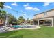 Lush backyard showcasing the sparkling pool, manicured lawn, lounge seating, and string lights at 21266 S 213Th Pl, Queen Creek, AZ 85142