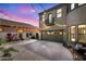 Backyard view showcasing covered parking and relaxing swing with landscape lighting at dusk at 21266 S 213Th Pl, Queen Creek, AZ 85142