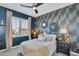 Inviting bedroom with patterned wallpaper, neutral linens, ceiling fan, and plantation shutters at 21266 S 213Th Pl, Queen Creek, AZ 85142