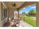 Inviting covered patio with dining set, offering backyard views of the lawn and play structure at 21266 S 213Th Pl, Queen Creek, AZ 85142