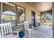 Inviting front porch with rocking chairs, blue accents, and a welcoming view at 21266 S 213Th Pl, Queen Creek, AZ 85142
