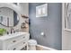 Stylish powder room with a vanity, round mirror, and modern finishes at 21266 S 213Th Pl, Queen Creek, AZ 85142