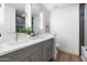 Bathroom featuring double sinks, gray cabinets, bright white walls, and a large framed mirror at 2156 E Cairo Dr, Tempe, AZ 85282