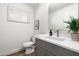 A bathroom featuring gray cabinets, bright white walls and a toilet at 2156 E Cairo Dr, Tempe, AZ 85282