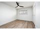 A bedroom featuring a ceiling fan, bright white walls, wood floors and a large window at 2156 E Cairo Dr, Tempe, AZ 85282