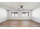 A bedroom featuring a ceiling fan, bright white walls, wood floors and two large windows at 2156 E Cairo Dr, Tempe, AZ 85282