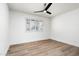 A bedroom featuring a ceiling fan, bright white walls, wood floors and a large window at 2156 E Cairo Dr, Tempe, AZ 85282