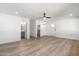 Spacious living room with wood-look floors, modern ceiling fan, and bathroom access at 2156 E Cairo Dr, Tempe, AZ 85282