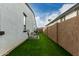 Narrow backyard with artificial grass between houses, offering a low-maintenance outdoor space at 23503 S 228Th Pl, Queen Creek, AZ 85142