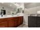 Bright bathroom featuring a double sink vanity with wood cabinets, quartz countertops, and a glass shower at 23503 S 228Th Pl, Queen Creek, AZ 85142
