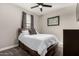 This bedroom features a comfortable queen bed, ceiling fan and a window for natural light at 23503 S 228Th Pl, Queen Creek, AZ 85142