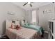 Light-filled bedroom with twin beds, shelves, and a large window, creating a cozy atmosphere at 23503 S 228Th Pl, Queen Creek, AZ 85142