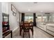 Open dining room with wood table, 6 chairs, dark curtains and convenient access to the living room and backyard at 23503 S 228Th Pl, Queen Creek, AZ 85142