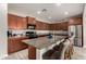 Spacious kitchen with granite countertops, wood cabinets, stainless appliances, and island with bar stool seating at 23503 S 228Th Pl, Queen Creek, AZ 85142