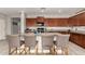 Kitchen boasts granite counters, wood cabinets, stainless appliances, island with seating for four, and wood look flooring at 23503 S 228Th Pl, Queen Creek, AZ 85142