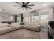 Bright living room with hardwood floors, a modern ceiling fan, and a large sofa at 23503 S 228Th Pl, Queen Creek, AZ 85142