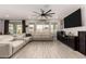 Bright living room features a large sectional sofa, wood-look tile flooring, and sliding glass doors to the backyard at 23503 S 228Th Pl, Queen Creek, AZ 85142