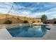 Inviting backyard pool with lovely rock waterfall, providing a relaxing and stylish outdoor retreat at 23503 S 228Th Pl, Queen Creek, AZ 85142