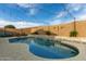 Backyard pool with a charming rock waterfall, complemented by ambient string lights for evening enjoyment at 23503 S 228Th Pl, Queen Creek, AZ 85142