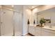 Bright bathroom featuring double sinks, white cabinets, glass enclosed shower, and a large mirror at 24645 N 164Th Dr, Surprise, AZ 85387