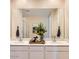 Elegant bathroom featuring double sinks, white cabinets, and a large mirror with modern decor at 24645 N 164Th Dr, Surprise, AZ 85387