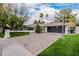 A stylish single-story home with a brick driveway, modern garage door, and basketball hoop at 26 W Morten Ave, Phoenix, AZ 85021