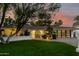 Charming single-story home with a lush green lawn and a stylish, modern garage door at 26 W Morten Ave, Phoenix, AZ 85021