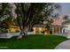 Charming single-story home with a lush green lawn and a stylish, modern garage door at 26 W Morten Ave, Phoenix, AZ 85021