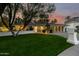 Charming single-story home with a lush green lawn and a stylish, modern garage door at 26 W Morten Ave, Phoenix, AZ 85021