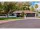 Single-story home boasts manicured landscaping, a modern garage door, and a spacious driveway at 26 W Morten Ave, Phoenix, AZ 85021