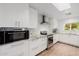 Modern kitchen is adorned with white cabinets, granite countertops, and stainless steel appliances for culinary enthusiasts at 26 W Morten Ave, Phoenix, AZ 85021