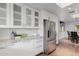 Modern kitchen features stainless steel appliances, white cabinets, granite countertops, and wood-look floors at 26 W Morten Ave, Phoenix, AZ 85021