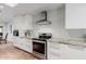 Well-equipped kitchen featuring stainless steel appliances, granite counters, tile backsplash, and ample white cabinetry at 26 W Morten Ave, Phoenix, AZ 85021
