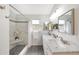 Beautiful bathroom featuring double sinks, stone floors, walk-in shower, and bright natural light at 2627 E Gary Way, Phoenix, AZ 85042