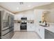 Well-lit kitchen with stainless steel appliances, white cabinets, and a corner sink at 2627 E Gary Way, Phoenix, AZ 85042