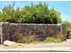 Stone community sign surrounded by lush plants and colorful flowers in a beautiful neighborhood entrance at 2627 E Gary Way, Phoenix, AZ 85042