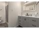 Modern bathroom featuring gray vanity and sink, mirror, and tiled shower at 2826 E Cactus Rd, Phoenix, AZ 85032