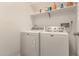 Bright laundry room with white washer and dryer and shelf storage at 2826 E Cactus Rd, Phoenix, AZ 85032