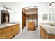 Dual sink bathroom with custom cabinets and a walk-in closet at 316 E Bethany Home Rd, Phoenix, AZ 85012