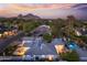 Picturesque twilight aerial view highlighting the pool, patio, and mountain backdrop of this charming home at 3429 E Coolidge St, Phoenix, AZ 85018
